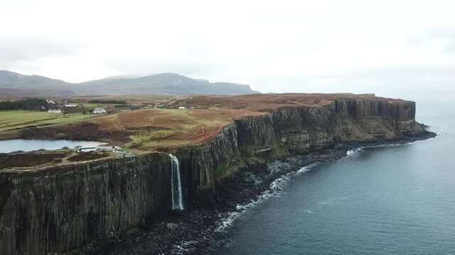 Giant waterfall over a rocky cliff into the Atlantic Ocean at Kilt Rock Isle of Skye, Scotland.