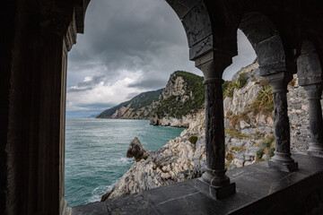 Columns of famous gothic Church of St. Peter (Chiesa di San Pietro) with beautiful shoreline scenery in Porto Venere village on the Ligurian coast of northwestern Italy