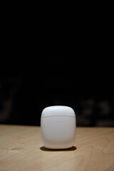 the case for wireless headphones is on the table the closed cover of the headphones the background is blurred