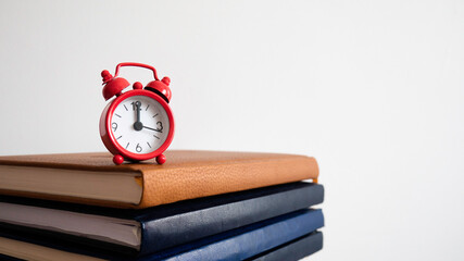 The red clock at the top of the notebooks. Job deadline.