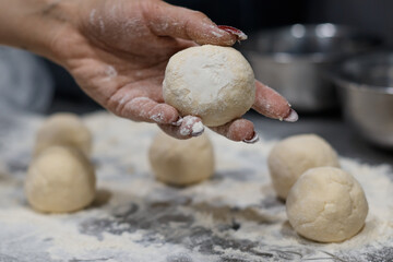 girl chef preparing dough makes the cheesecakes in the kitchen close up blurred background