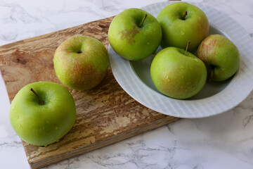 green, healthy apples in a white plate