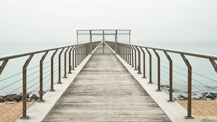 Obraz premium Puerta en un puente peatonal que da al mar para contemplar 