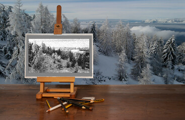 drawing easel with pencils on wooden table with mountain views