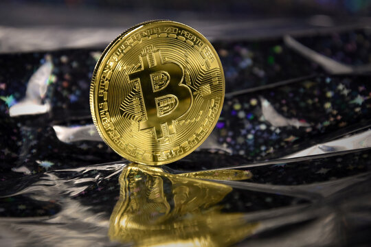 One bitcoin golden coin stock images. Cryptocurrency on a shiny dark background. Digital gold images. Beautiful gold bitcoin coin photo images