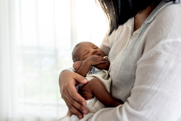 Portrait images of half African half Thai, 12-day-old baby newborn son, sleeping with his mother being held, to family and infant newborn concept. - Powered by Adobe