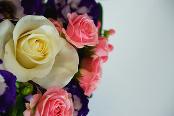 Background. Bouquet of flowers close-up on a white background. White and pink roses, blue-white eustoma. Place for text.