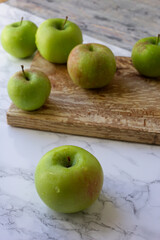 green apples on a wooden board for slicing