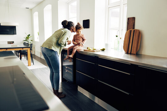 Loving Mom And Her Little Daughter Eating A Snack At Home