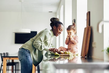 Foto op Aluminium Smiling mom and her cute little daughter eating a healthy snack © Flamingo Images