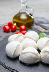 Tasty italian food, fresh white buffalo mozzarella soft cheese balls from Campania, tomatoes, fresh basil and olive oil