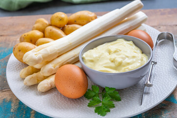 Ingredients for spring vegetarian dinner, high quality Dutch white asparagus, washed and peeled on board, ready to cookand, young potatoes, eggs and sauce