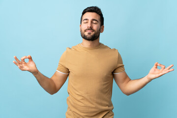 Young handsome man with beard over isolated background in zen pose