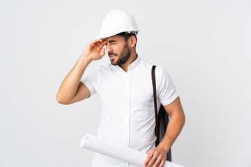 Young architect man with helmet and holding blueprints isolated on white background with tired and sick expression