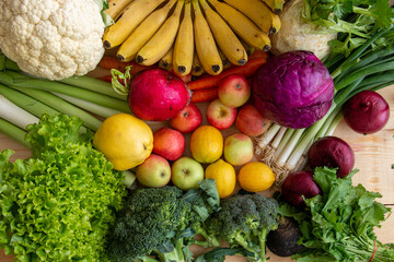 Fill your fridge with healthy vegetables and fruits. Many vegetables and fruits are sitting on the table.