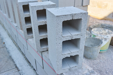 worker builds a cinder block wall for a new home
