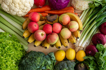 Many healthy organic vegetables and fruits are sitting on the table.