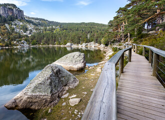 Wooden path around the glacial lake wtih mountain reflected in Laguna Negra in Urbion Glaciar Circos Natural Park, Soria, Castilla León, Spain © Ania