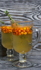 Cocktail with sparkling wine and sea buckthorn. Sea buckthorn bellini. Decorated with thyme sprigs.