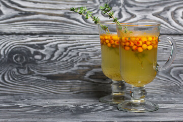 Cocktail with sparkling wine and sea buckthorn. Sea buckthorn bellini. Decorated with thyme sprigs.