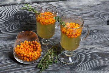 Cocktail with sparkling wine and sea buckthorn. Sea buckthorn bellini. Decorated with thyme sprigs.