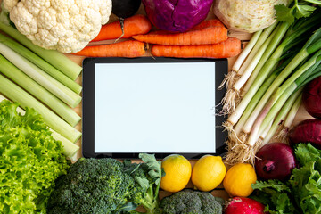 Isolated tablet screen among healthy food vegetables. tablet for writing diet notes.