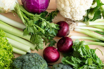 organic vegetables, purple onion, celery, leek, broccoli, cauliflower are on the table.