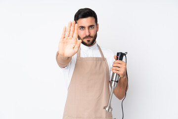 Man using hand blender isolated on white background making stop gesture with her hand