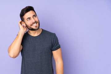 Caucasian handsome man thinking an idea over isolated purple background