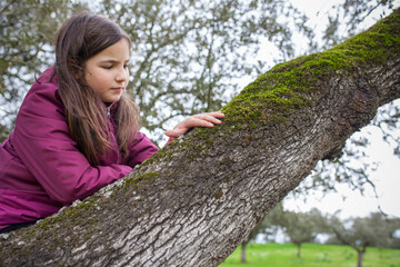 Child girl feeling tree moss over branch