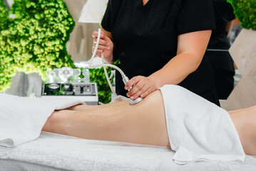 A young pretty girl is enjoying a professional vacuum massage at the Spa. Body care. Beauty salon