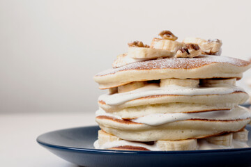 Stack of American pancakes with butter cream, apple and banana