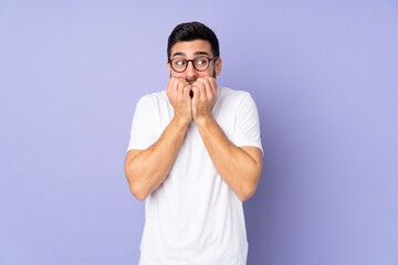 Caucasian handsome man over isolated background nervous and scared putting hands to mouth