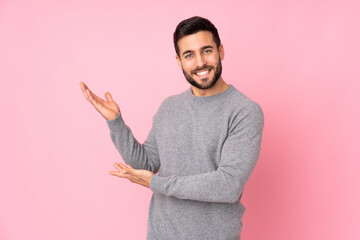 Caucasian handsome man over isolated background extending hands to the side for inviting to come