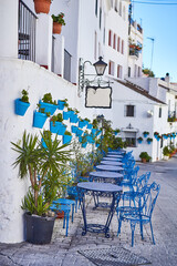 Fototapeta na wymiar Picturesque street of Mijas with flower pots on facades. Andalusian white town. Cost of the Sun. Southern Spain
