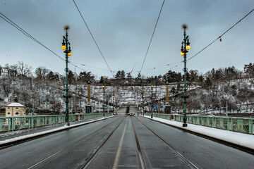 Bridge across Vltava River with tram railway, Letna park and Prague Metronome in background,...