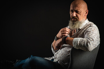 close up, portrait of an emotional, thoughtful, handsome young bearded businessman man sitting on a...