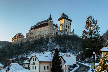 Fototapeta na wymiar Beautiful gothic Royal Karlstejn Castle in winter with snow,Czech Republic.Founded by Charles IV.There are Czech crown jewels, holy relics, and royal treasures.Most popular Czech castle at sunset.
