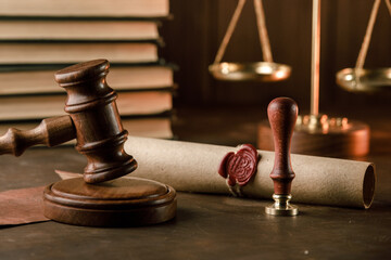 Vintage notary stamp, gavel and sealed document on a wooden table.