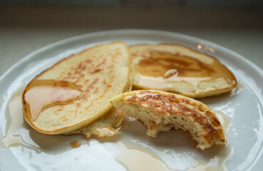flapjacks half eaten on a plate with syrup