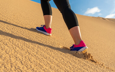 Plakat sportswoman running in the dunes - selective focus 