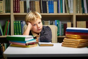 sleepy little boy tired of learning doing homework reading book, studying preparing for exam test, literature research, children education concept