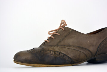 Female leather shoes located on a white background. Oxford shoes with gray shoelaces on a flat heel. Gray women's shoes in a fastening, unwitting. 