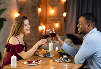 Romantic Multiethnic Couple Clinking Glasses With Wine On Date In Restaurant