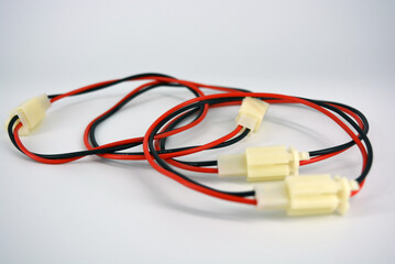 Large electric red black wires on 12V, 220V with white plastic dad connector and mom located on a white plastic background.
