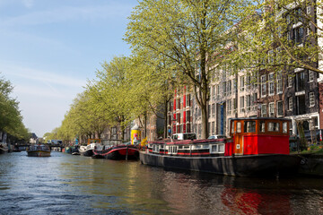 Fototapeta na wymiar Europe, Netherlands, Amsterdam. Canal tour boat and cityscape.