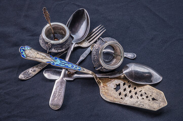 vintage silver utensils on a black surface close up
