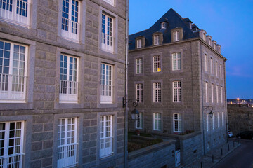 Naklejka premium View at sunset from the wall of the old city with granite buildings of Saint-Malo in Brittany, France