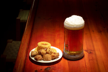 Pescado frito surtido y una cerveza fría en una barra de bar
