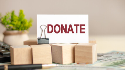 piece of paper with the text: DONATE, business and finance concept